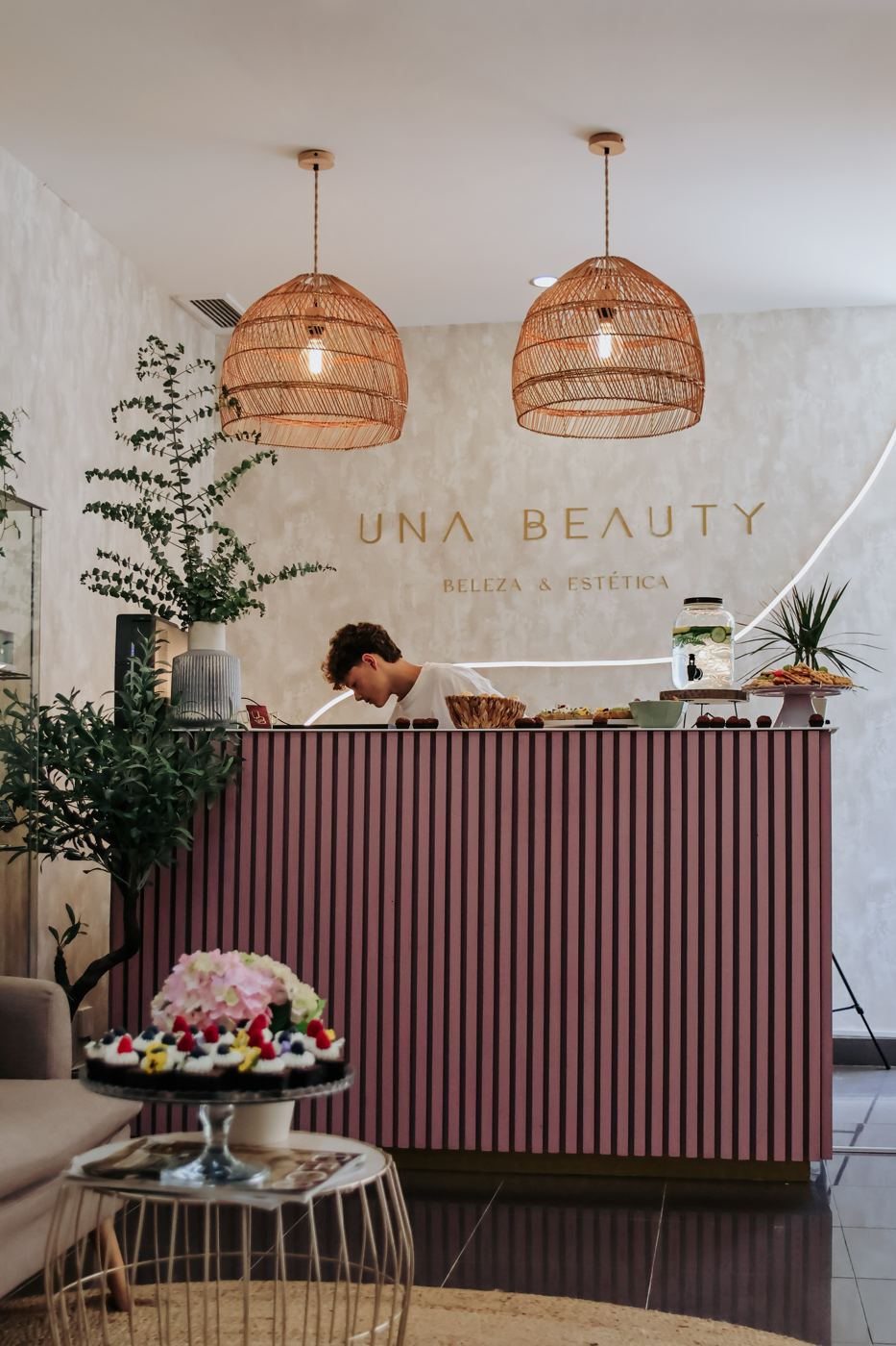 Recepção do salão Una Beauty em Cascais, com letreiro dourado e candeeiros de rattan